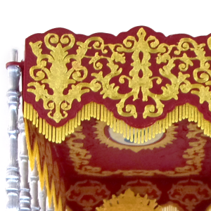 Detalle de la bambalina frontal del palio burdeos en miniatura con bordados dorados.